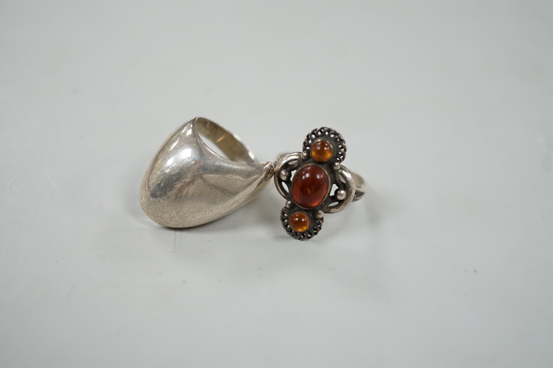 A Georg Jensen sterling ring, design no. 91, size Q and a Georg Jensen? sterling and three stone amber set ring, design no. 15.